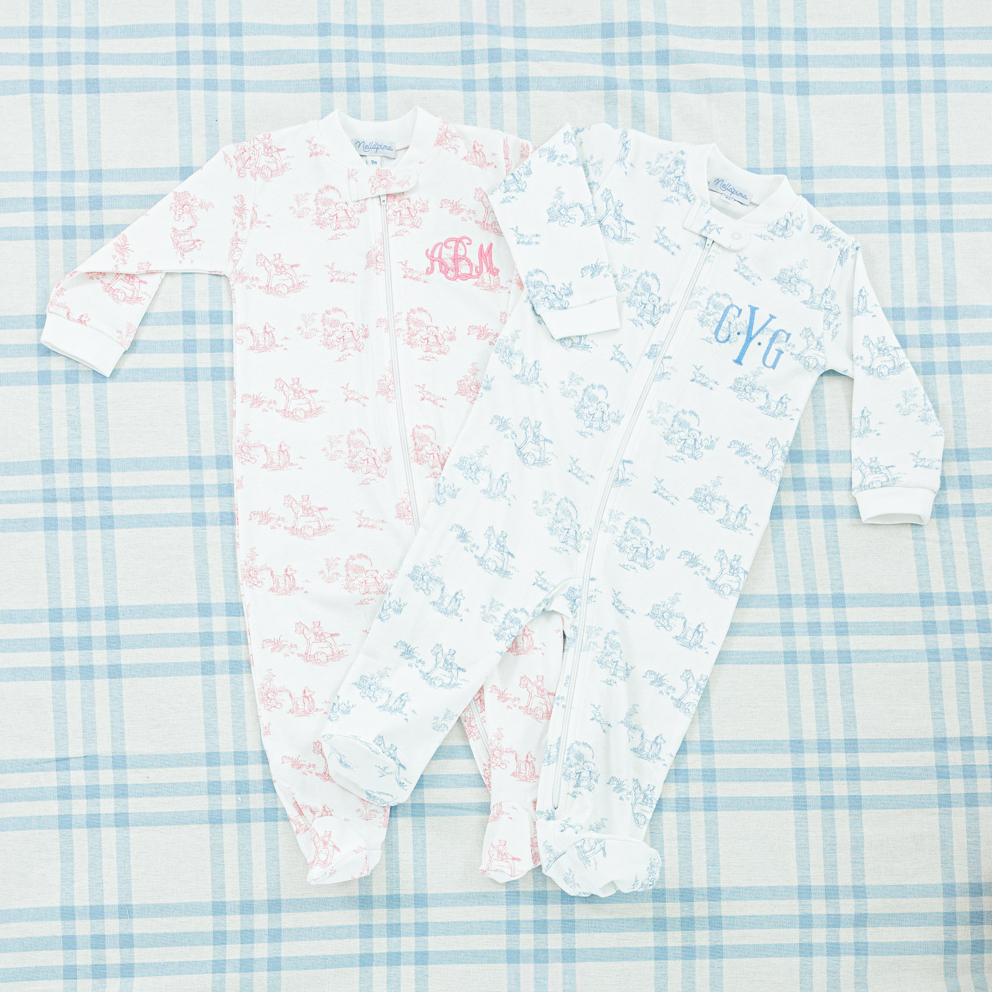 Two baby patterned onesies, both featuring a footed design with long sleeves