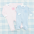 Two baby onesies, one in light blue and the other in soft pink.