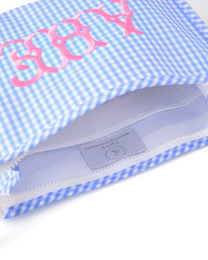 Blue gingham pouch with pink monogram embroidery, showing the interior and zipper detail.