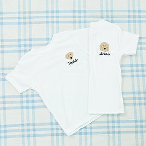 Two white children's shirts, each featuring an embroidered teddy bear face and personalized with the names