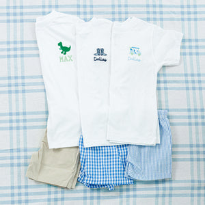 Three white t-shirts with personalized embroidery, each paired with matching shorts. 