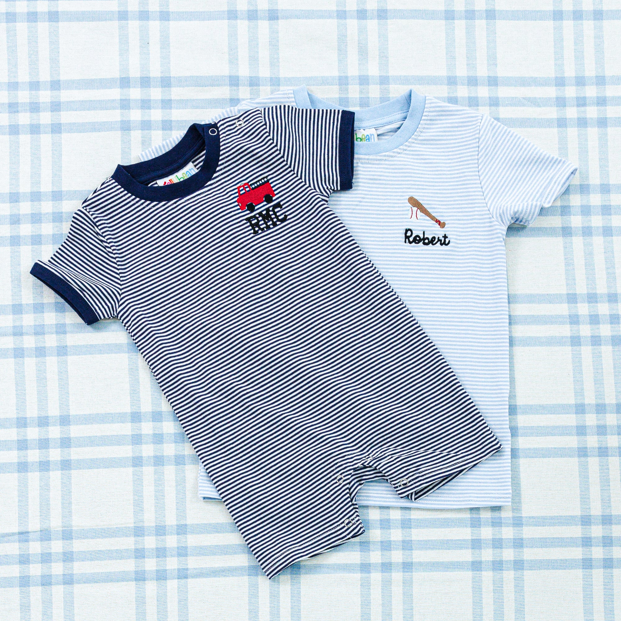 Striped baby onesie with navy accents and a red crab motif