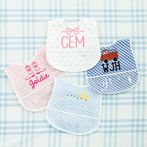 Set of four personalized baby bibs in various designs and colors, each embroidered with names and images