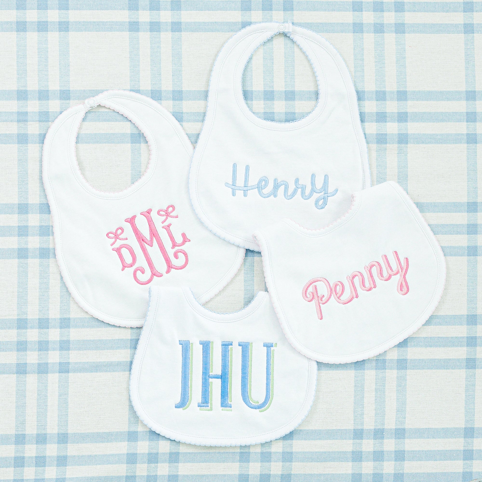 White baby bibs with delicate trim details, designed for comfort and easy cleaning.