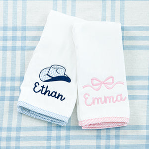 Two white hand towels, each with coordinating blue and pink gingham trim.