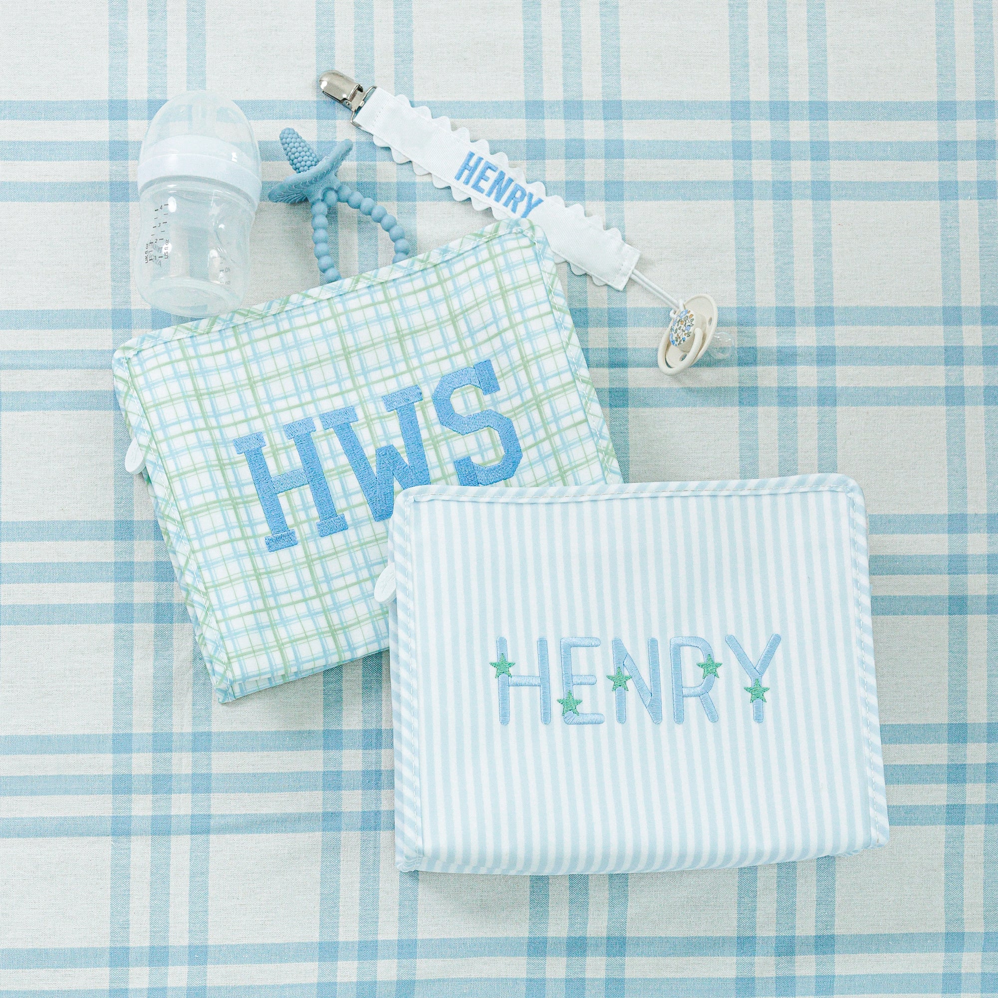 Three personalized bags: a plaid, a blue-striped bag and a pink gingham bag.