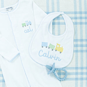 Personalized baby bib embroidered with a colorful train design and the name "Calvin."