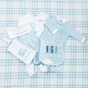 Personalized baby set featuring a blue and white themed collectio all embroidered with names.