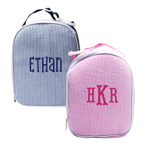 Two personalized seersucker bags: a blue bag with 'Ethan' name and a pink bag with 'HKR' initials.