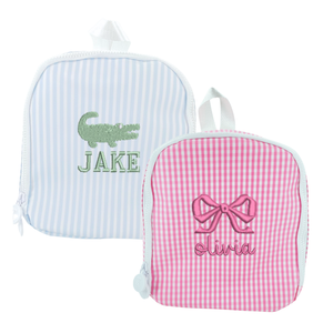 Two personalized children's bags: a blue-striped bag with an alligator design and a pink gingham bag with a bow design.